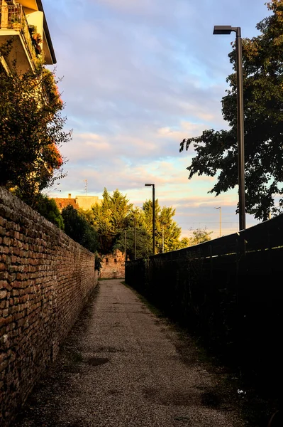 日落时在砖墙和栅栏之间的小巷 — 图库照片
