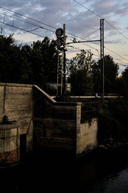 Gün batımında bulutlu bir günde köprüdeki tren yolu.