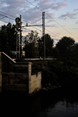 Gün batımında bulutlu bir günde köprüdeki tren yolu.