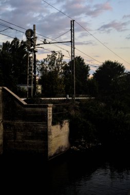 Gün batımında bulutlu bir günde köprüdeki tren yolu.