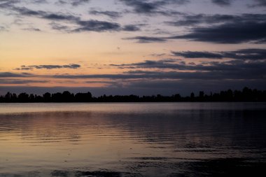 Sonbaharda bir göl üzerinde günbatımı