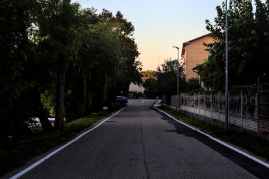 İtalya kırsalında, gün batımında bir gölün kıyısında.