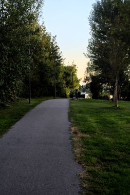 Gün batımında gölün yanındaki parkta çakıl patikası.