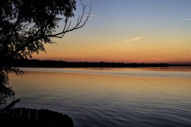 Gün batımında ağaçlarla çevrili göl
