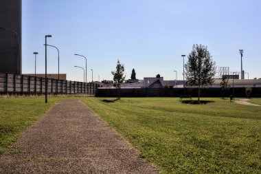 Güneşli bir günde, yerleşim yerinin parkındaki çakıl yolu.