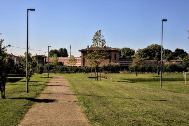 Güneşli bir günde, yerleşim yerinin parkındaki çakıl yolu.