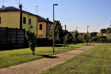 Güneşli bir günde, yerleşim yerinin parkındaki çakıl yolu.