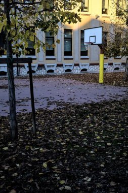 Gün batımında okulun arka bahçesinde basketbol potası.