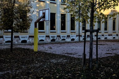 Gün batımında okulun arka bahçesinde basketbol potası.