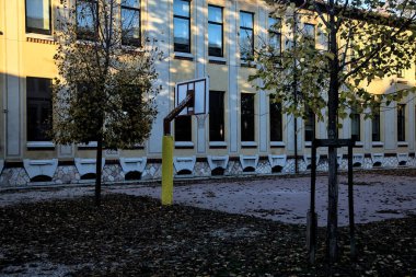 Gün batımında okulun arka bahçesinde basketbol potası.