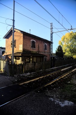 Gün batımında tren yolunun kenarındaki eski tuğla bina.