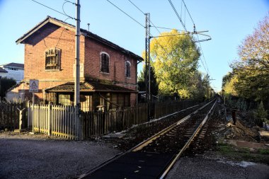 Gün batımında tren yolunun kenarındaki eski tuğla bina.