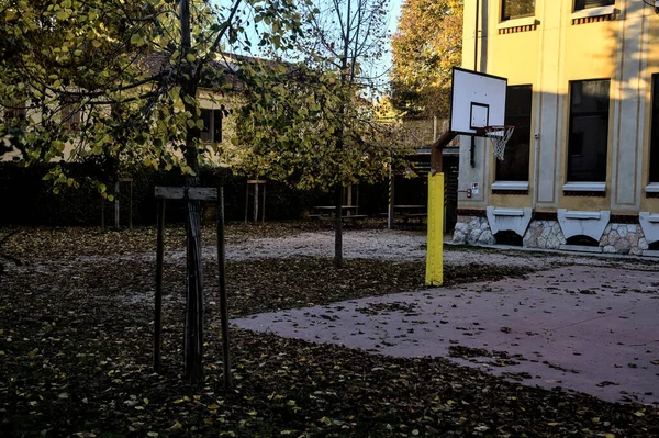 夕暮れ時に学校の裏庭でバスケットボールのフープ — ストック写真