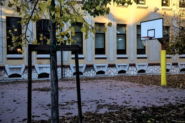 夕暮れ時に学校の裏庭でバスケットボールのフープ — ストック写真