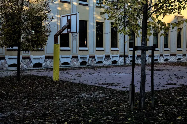 Gün batımında okulun arka bahçesinde basketbol potası.