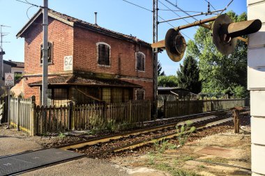 Gün batımında demiryolu kavşağının yanına bir bina.