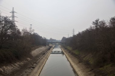 Bulutlu bir günde kışın ağaçlarla çevrili eğlence kanalı