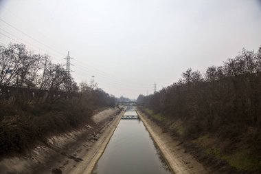 Bulutlu bir günde kışın ağaçlarla çevrili eğlence kanalı