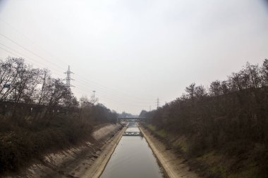 Bulutlu bir günde kışın ağaçlarla çevrili eğlence kanalı