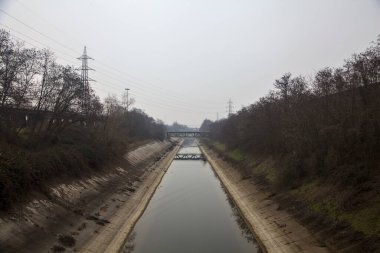 Bulutlu bir günde kışın ağaçlarla çevrili eğlence kanalı