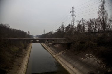 Bulutlu bir günde kışın ağaçlarla çevrili eğlence kanalı