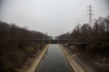 Bulutlu bir günde kışın ağaçlarla çevrili eğlence kanalı