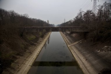 Bulutlu bir günde kışın ağaçlarla çevrili eğlence kanalı