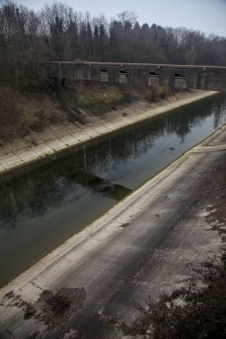 Bulutlu bir günde kışın ağaçlarla çevrili eğlence kanalı