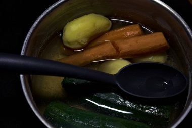 Sebzeli metal kap ve siyah arka planda kepçe