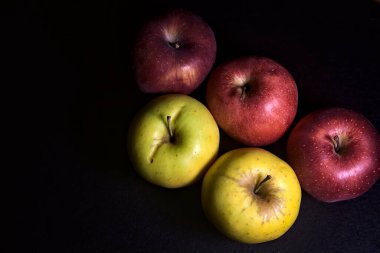 Siyah arkaplanda kırmızı ve sarı elmalar