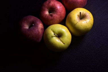 Siyah arkaplanda kırmızı ve sarı elmalar