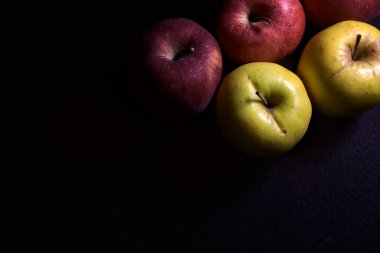 Siyah arkaplanda kırmızı ve sarı elmalar