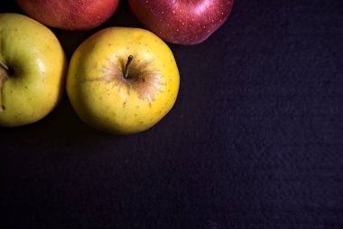 Siyah arkaplanda kırmızı ve sarı elmalar