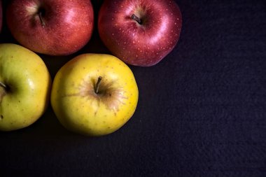 Siyah arkaplanda kırmızı ve sarı elmalar