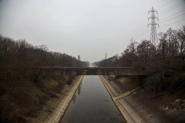 Bulutlu bir günde kışın ağaçlarla çevrili eğlence kanalı