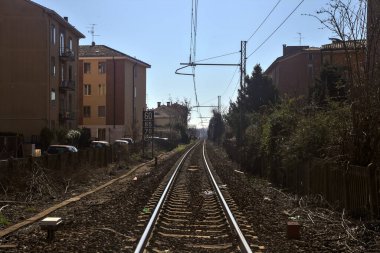 Açık bir günde bir yerleşim bölgesinde demiryolu hattı.