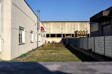 Arkasında terk edilmiş bir depo olan binalar arasındaki bir bahçenin soyulması.
