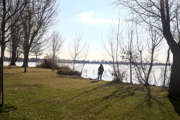 在阳光灿烂的日子里 一个女人站在湖边 — 图库照片
