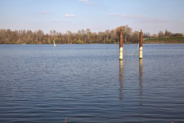Güneşli bir günde suya yansıyan bir gölde demirlemek.