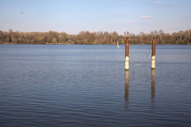 Güneşli bir günde suya yansıyan bir gölde demirlemek.