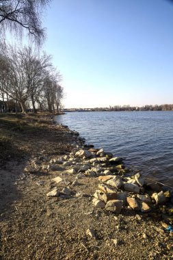 Güneşli bir günde bir gölün kayalık kıyısı