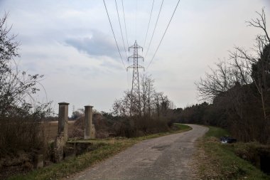 Bulutlu bir günde alacakaranlıkta, köy yolunun kenarındaki bir tarlaya giriş kapısı.