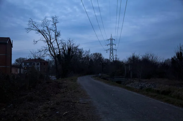 Bulutlu bir günde alacakaranlıkta, sınırında bir kapı olan kırsal bölgede yol