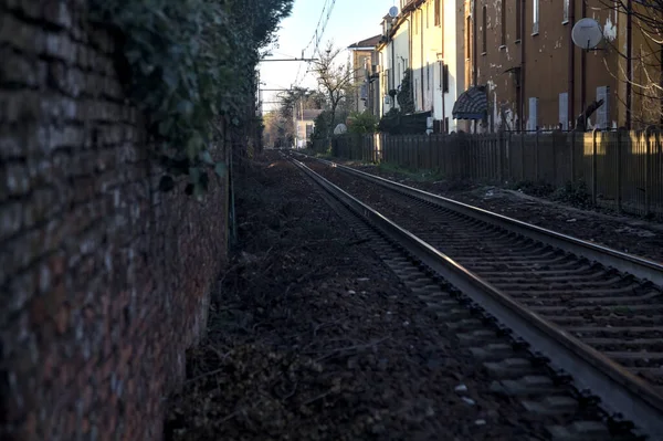 日落时在住宅区建筑物之间通过的铁路轨道 — 图库照片