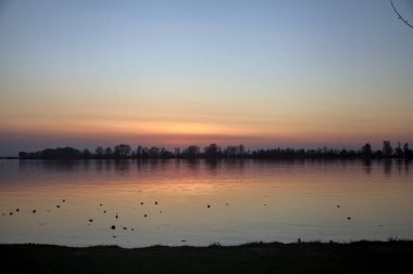 Gün batımında göl kıyıdan görünüyor.