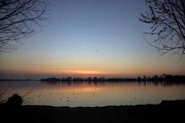 Gün batımında göl kıyıdan görünüyor.