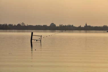 Gün batımında göl ve karşı kıyıda bir kasaba.