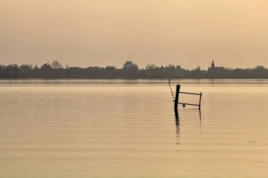 Gün batımında göl ve karşı kıyıda bir kasaba.