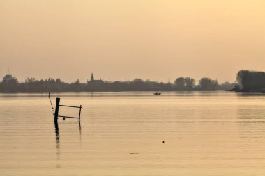 Gün batımında göl ve karşı kıyıda bir kasaba.