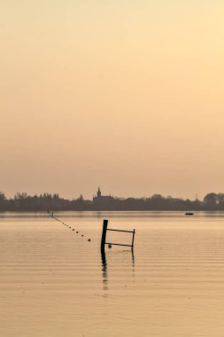 Gün batımında göl ve karşı kıyıda bir kasaba.